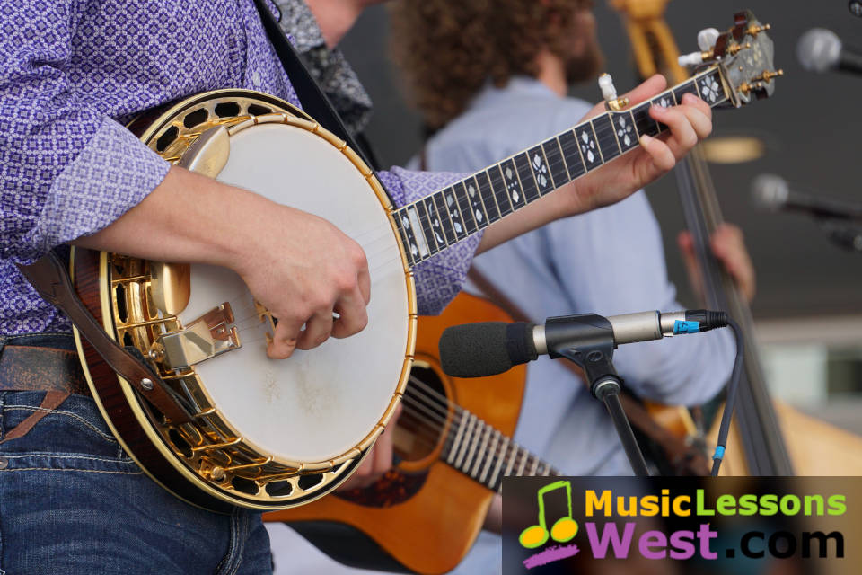 Featured image for "Banjo Lessons Nashville TN' page on MusicLessonsNashville.com depicting a close up shot of a banjo being played in a bluegrass band.